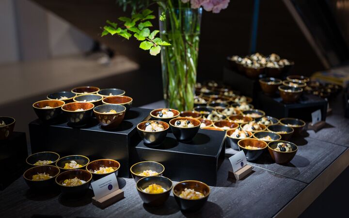 Buffet mit kleinen Schalen auf schwarzen Podesten, dazwischen Hortensien in einer hohen Glasvase.