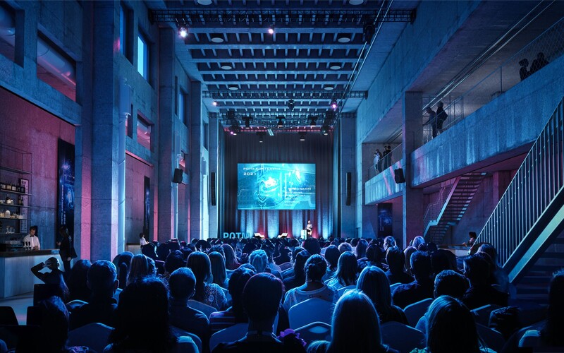 Eine Veranstaltung in der Eventhalle von JED Events mit Blick auf die Bühne mit einem grossen Screen.