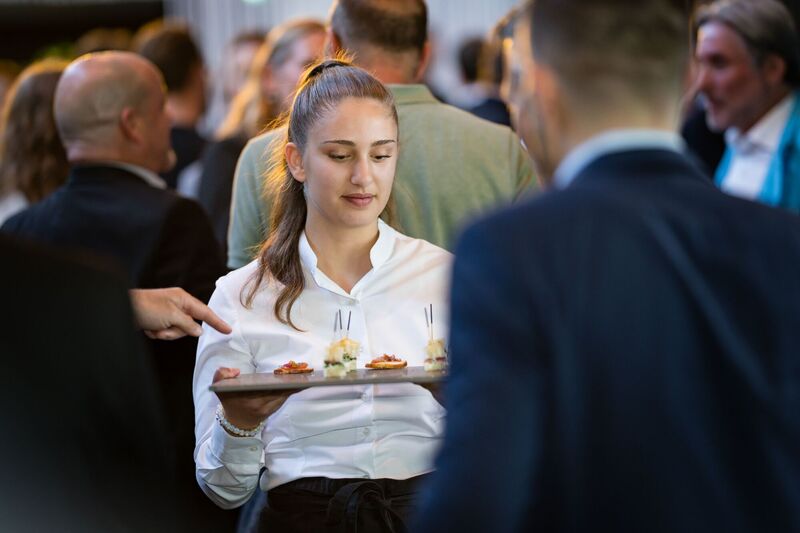 Eine Serviceangestellte von JED Events mit einer Apéroplatte bei einem Catering.