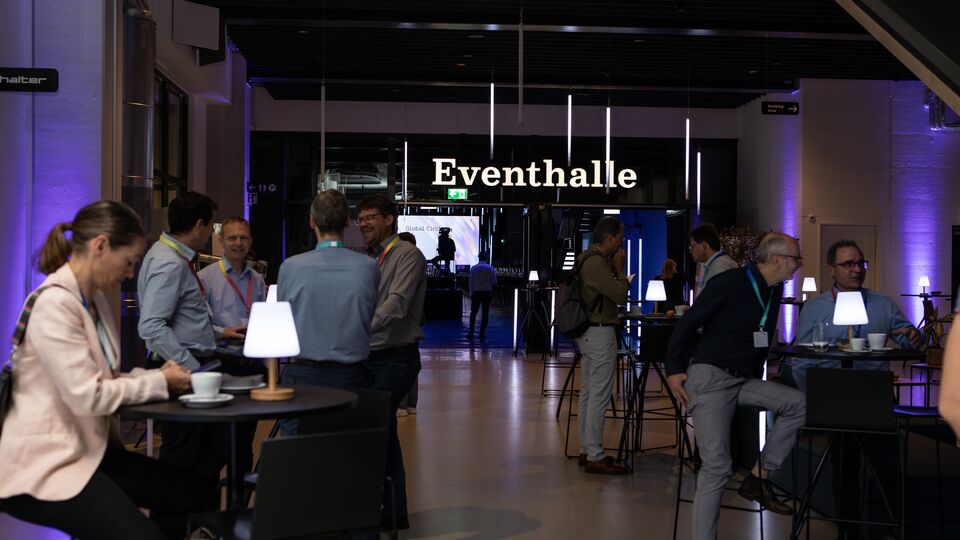 Networking an Stehtischen bei einem Kongress in der JED Eventhalle.