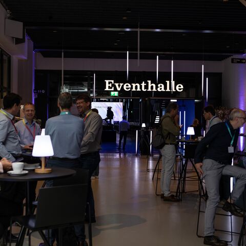 Networking at standing tables at a congress in the JED Events hall.