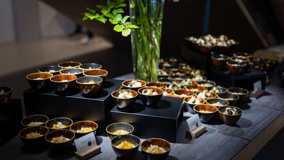 Buffet mit kleinen Schalen auf schwarzen Podesten, dazwischen Hortensien in einer hohen Glasvase.