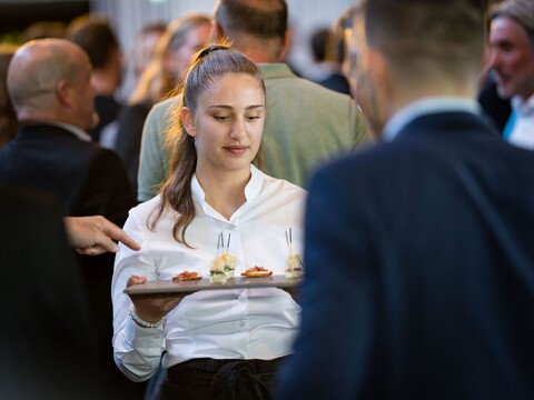 Eine Serviceangestellte von JED Events mit einer Apéroplatte bei einem Catering.