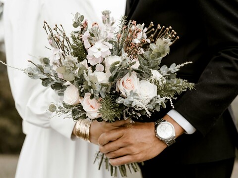 Zwei frisch verheiratete Menschen, die sich an der Hochzeitsfeier bei JED Events die Hand geben.