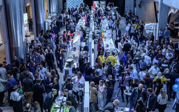 Gut besuchte Messe im JED von der Galerie aus fotografiert, mit langen Ausstellungsreihen und Besuchenden.