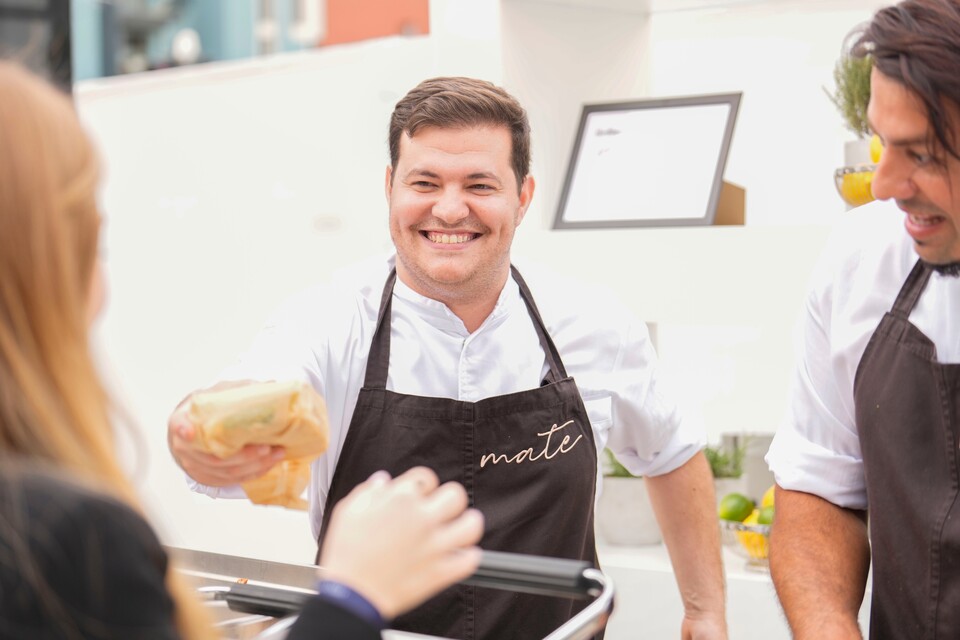 Freundlicher Koch bedient Gäste an der Livecooking Station