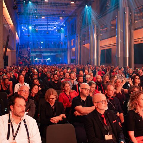 Eine Veranstaltung mit vielen Gästen in der bestuhlten grossen Eventhalle von JED Events.