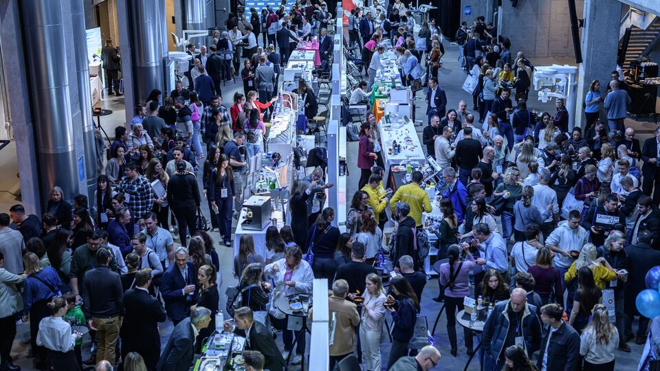 Gut besuchte Messe im JED von der Galerie aus fotografiert, mit langen Ausstellungsreihen und Besuchenden.